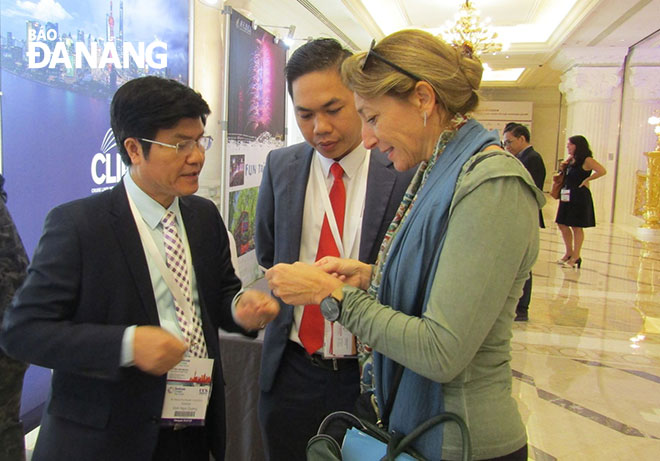 Director of the municipal Tourism Department Ngo Quang Vinh (left) and Mr Son Thuy (centre) advertising the city’s tourism images in a foreign country