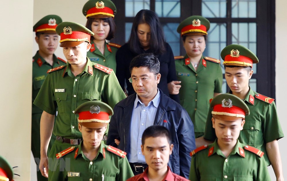Bị cáo Nguyễn Văn Dương (giữa) cùng các bị cáo được cơ quan chức năng dẫn giải ra tòa. (Ảnh: Trung Kiên/TTXVN)