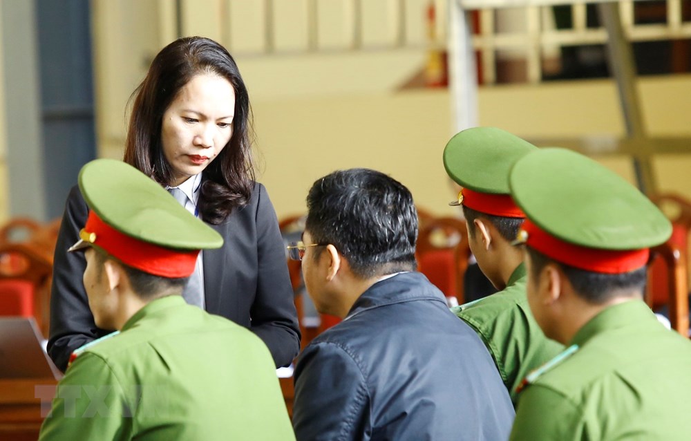 Luật sư bào chữa nói chuyện với bị cáo Nguyễn Văn Dương trước giờ xét xử. (Ảnh: Trung Kiên/TTXVN)