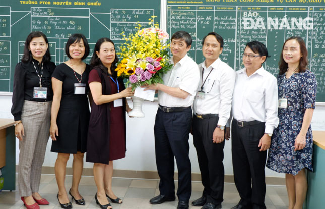 Da Nang People's Committee Vice Chairman Dang Viet Dung presenting flowers to representatives from municipal Integrated Education Development Centre on their special day