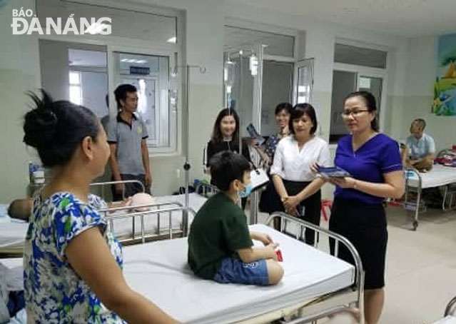 Chị Trần Thị Thùy Trâm (thứ 4 từ phải sang) cùng các chị em Điện lực Thanh Khê đến tặng quà một bệnh nhi nhân Tháng Tri ân khách hàng. Ảnh: T.N