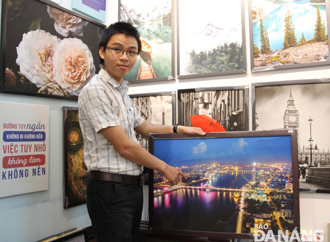 Nguyễn Mạnh Tuấn bên bức ảnh Toàn cảnh Đà Nẵng từng góp mặt trong nhiều triển lãm trong và ngoài nước. Ảnh: Lam Phương