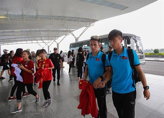 Hai cầu thủ Hồng Duy (trái) và Văn Đức vào làm thủ tục tại sân bay quốc tế Nội Bài (Hà Nội). (Ảnh: Trọng Đạt/TTXVN)