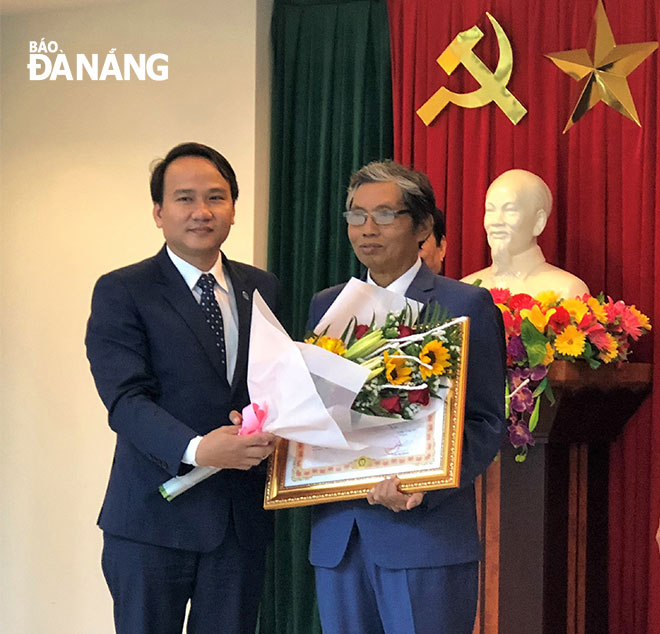 Giám đốc Sở GD&ĐT thành phố Nguyễn Đình Vĩnh (trái) trao bằng công nhận danh hiệu Nhà giáo Ưu tú cho thầy giáo Hoàng Văn Khánh vào ngày 26-1-2018.