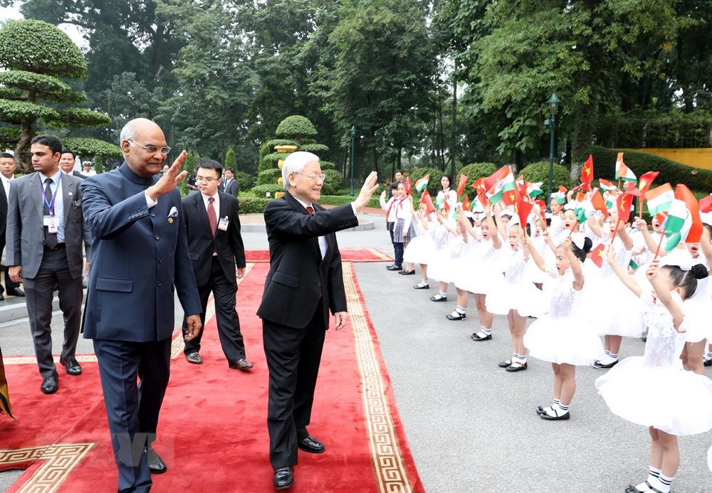 Tổng Bí thư, Chủ tịch nước Nguyễn Phú Trọng và Tổng thống Ấn Độ Ram Nath Kovind vẫy chào các cháu thiếu nhi Hà Nội tại lễ đón. (Ảnh: Trí Dũng/TTXVN)
