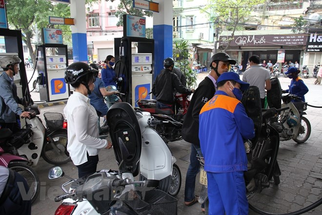 Nhân viên Petrolimex đang bán xăng cho khách hàng. (Ảnh: Đức Duy/Vietnam+)