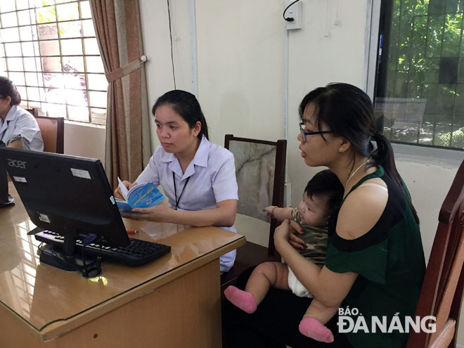 Mẹ và bé tham gia tư vấn chương trình tiêm chủng tại Trung tâm Kiểm soát bệnh tật thành phố.