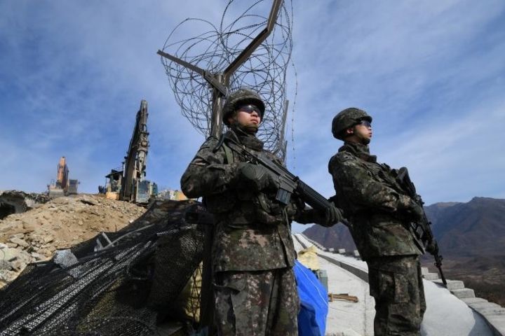 Lính gác có vũ trang của Hàn Quốc đang đứng bảo vệ việc phá dỡ.