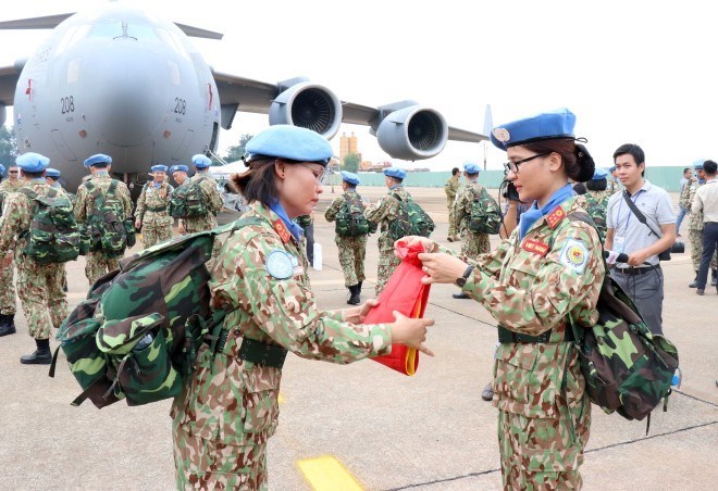 Two members of the level-2 field hospital folded the military flag before the departure of the peacekeeping force in October 2018. (Photo: VNA)