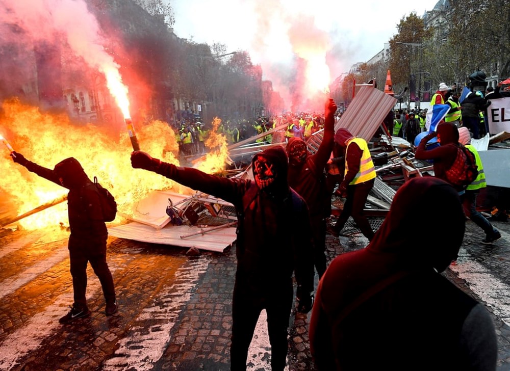 Người biểu tình cầm pháo sáng và đeo mặt nạ tại Đại lộ Champs-Élysées. (Nguồn: REX)