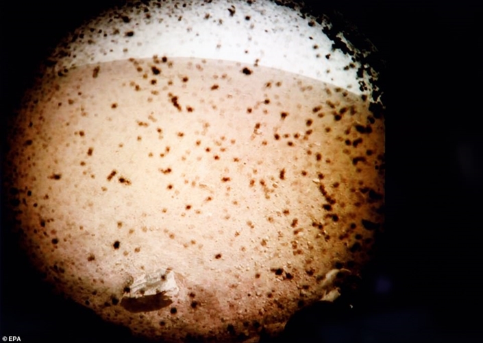 Hình ảnh bề mặt sao Hỏa do InSight gửi về không rõ nét vì lớp bụi vẫn còn trên ống kính máy ảnh, nhưng địa hình có vẻ khá mịn và được bao phủ bởi cát. Các nhà khoa học đang mong đợi có được nhiều bức ảnh đẹp hơn trong những ngày tới. Ảnh: EPA.