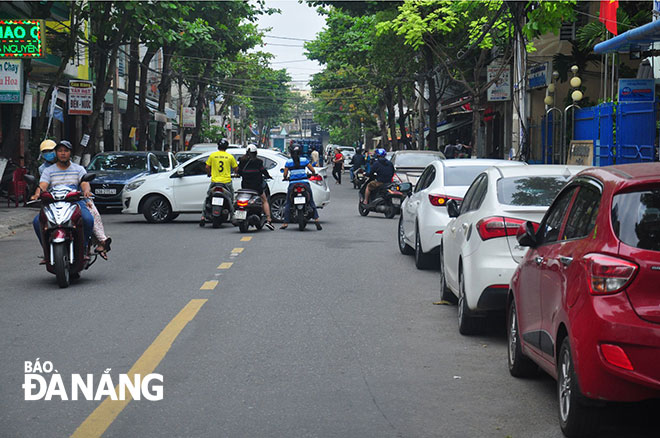 A number of cars parked by the side of the Ly Thuong Kiet street during rush hours  