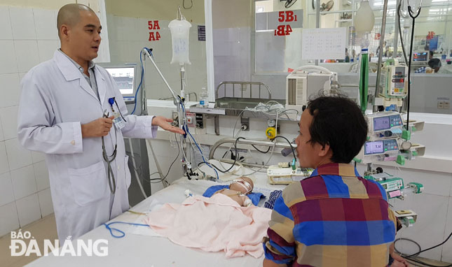 Bác sĩ Nguyễn Văn Ngữ, Bệnh viện Phụ sản-Nhi Đà Nẵng khám, tư vấn cho một bệnh nhi sốt xuất huyết.
