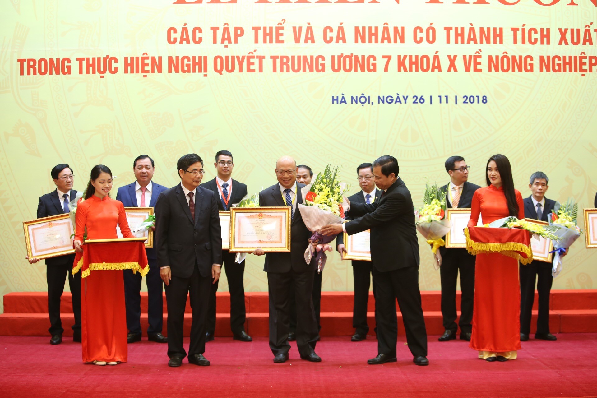 Ông Trịnh Quốc Dũng, Giám đốc Điều hành Vinamilk nhận bằng khen và hoa từ ông Cao Đức Phát, Phó Trưởng ban thường trực Ban Kinh tế Trung ương và ông Nguyễn Xuân Cường, Bộ trưởng Bộ Nông nghiệp và Phát triển nông thôn.
