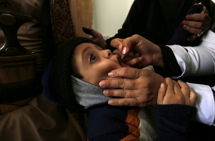 Một nhân viên y tế đang cho một em nhỏ uống vắc xin phòng bệnh bại liệt ở Sana's, Yemen ngày 27/11/2018. 