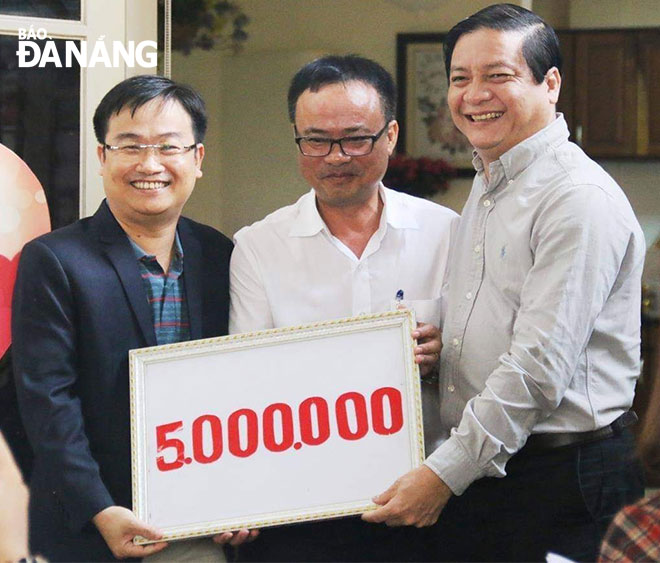 DA NANG Newspaper’s Deputy Editor-in-Chief Hua Van Hai (left) and Deputy Director of the Da Nang Radio and Television Hong Quang Nam (centre) receiving donations from a generous donor.