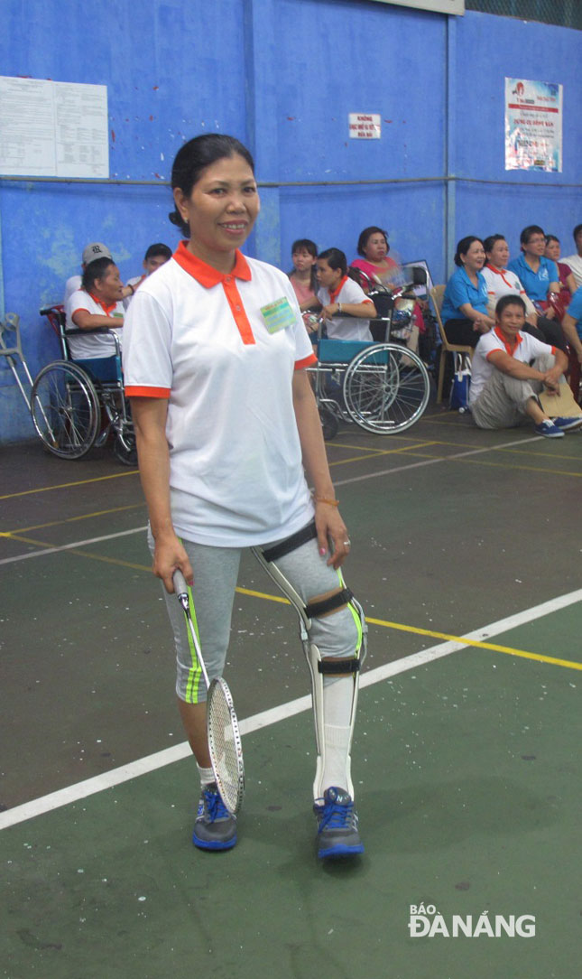 A disabled woman with an orthopaedic device participating in the badminton competition 