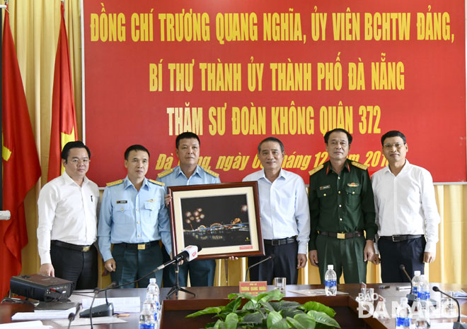 Bí thư Thành ủy Trương Quang Nghĩa (thứ ba, từ phải sang) tặng quà lưu niệm cho Sư đoàn 372.                   Ảnh: ĐẶNG NỞ
