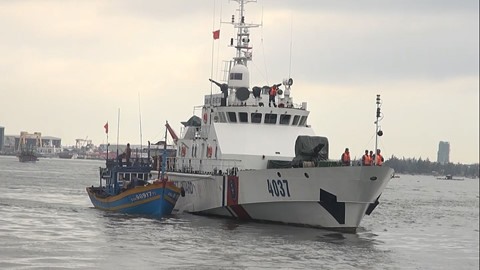 A rescue ship from the second regional coast guard tows the boat with nine fishermen on board to port. — Photo thanhnien.vn