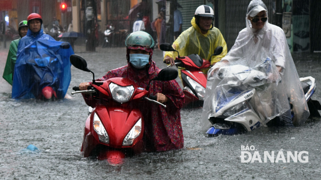 Road users managing to go through a flooded street