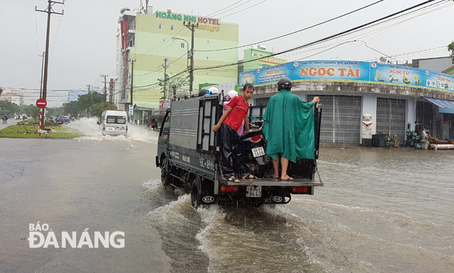 A semi-truck carrying motorbikes running through an inundated area near the city’s inter-provincial coach station at 10,000 VND per vehicle