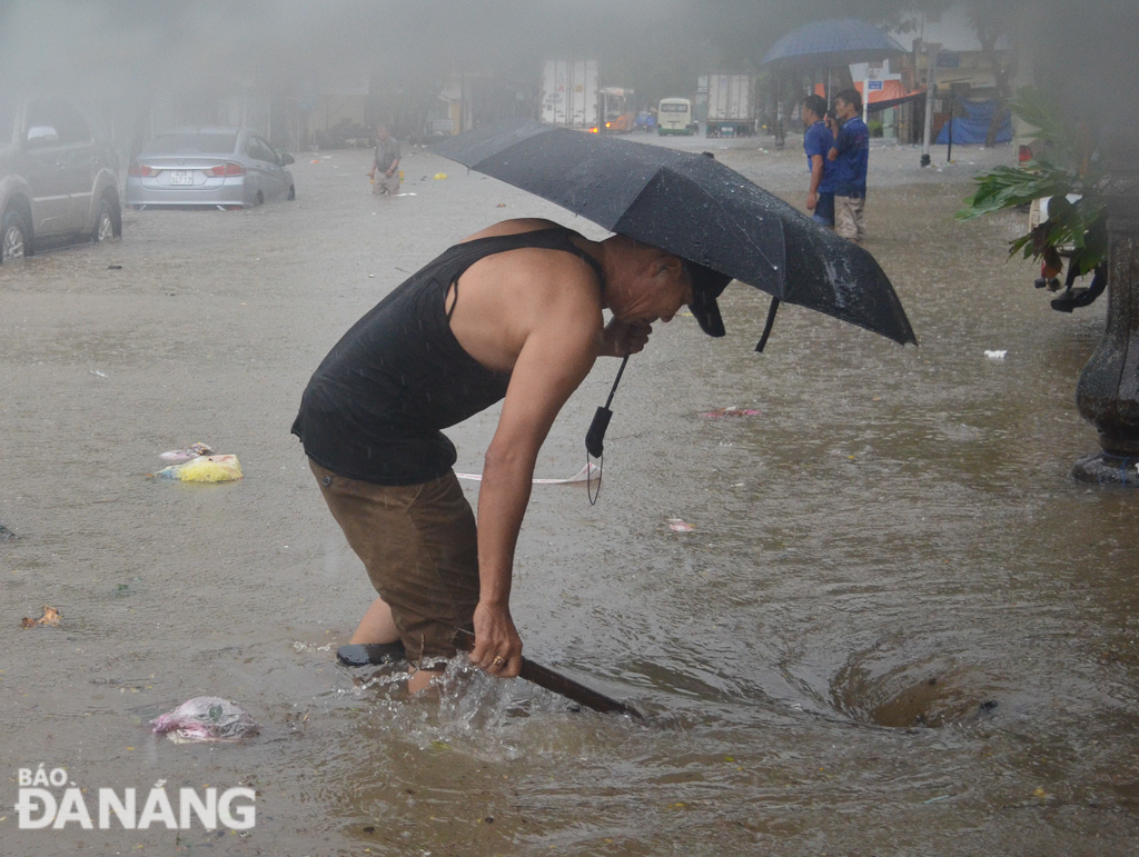 A male inhabitant unblocking a sewer on Tu Mo Street, behind the city’s inter-provincial coach station