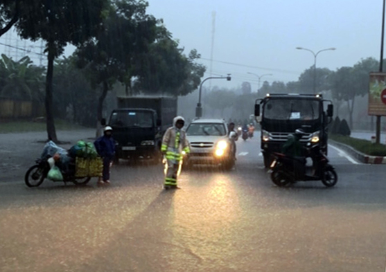 Traffic police preventing road users from running through a flooded area in the commune