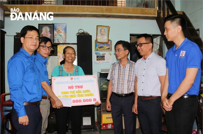 Chị Đặng Thị Minh vui mừng nhận được tiền hỗ trợ sửa chữa nhà từ các đoàn viên, thanh niên Đại học Đà Nẵng.