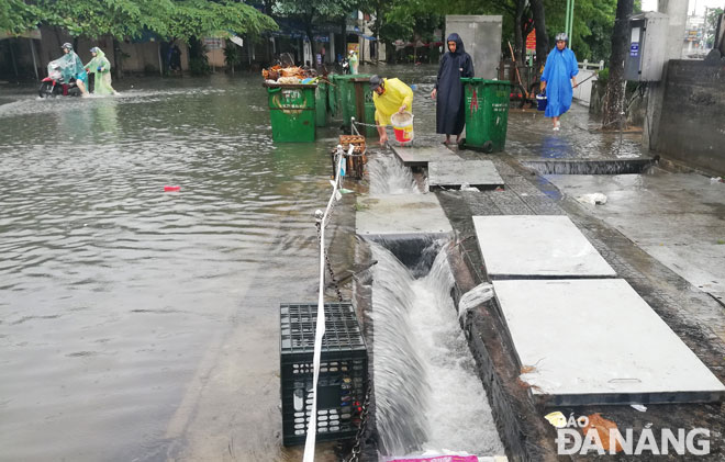Workers from the city's Water Drainage and Wastewater Treatment Company (DWTC) opening main sewers along Yen Khe Street for rainwater to quickly drain away