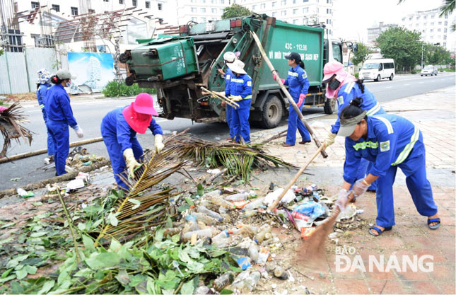 Công nhân Công ty CP Môi trường đô thị Đà Nẵng tăng cường thu gom rác thải sinh hoạt trên địa bàn thành phố và các bãi biển du lịch. Ảnh: HOÀNG HIỆP
