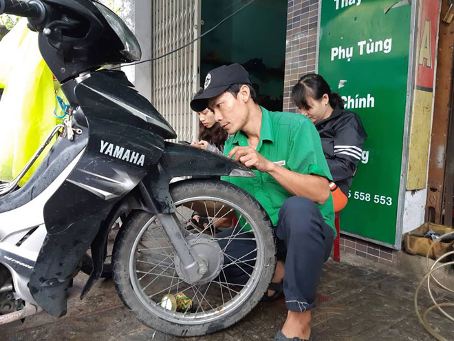 Anh Đặng Văn Thọ sửa chữa miễn phí xe máy bị hư hỏng do ngập nước. Ảnh: T.N