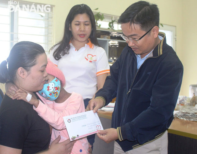 DA NANG Newspaper’s Deputy Editor-in-Chief Hua Van Hai handing 5 million VND funded by the ‘Ly Ca Phe Yeu Thuong’ programme to 7-year-old Phan Thi Thao Nhi who is suffering from myeloid leukemia