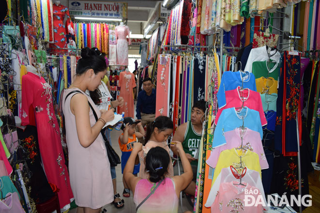 ‘Ao dai’ tailor measuring her child customer