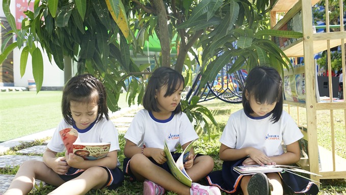 Children read at the open library of a primary school in Da Nang