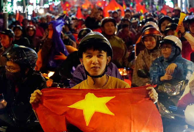 Cổ động viên Đà Nẵng mang theo cờ Tổ quốc xuống đường “đi bão” mừng Đội tuyển bóng đá Việt Nam chiến thắng hôm 15-12. Ảnh: KHẢ THỊNH