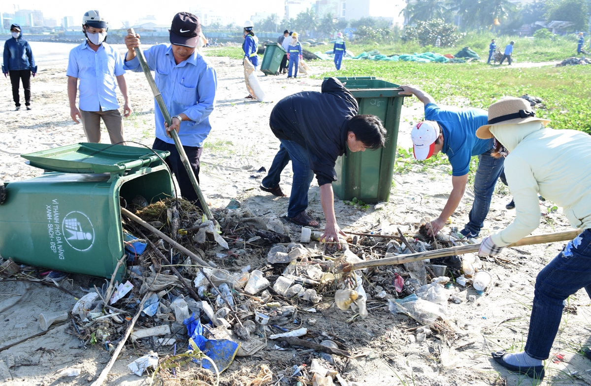 Cán bộ, nhân viên, công nhân của Công ty CP Môi trường đô thị Đà Nẵng thu gom rác thải trên bãi biển.