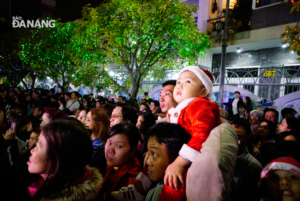 A little boy, in a lovely Santa Claus costume, along with his family members, enjoying the cozy Christmas ambience