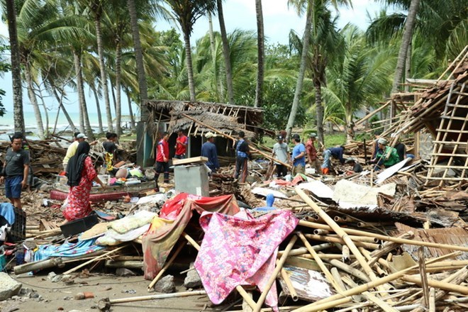 Indonesian residents return home after fleeing their houses when a tsunami struck Anyer beach. (Photo: VNA)