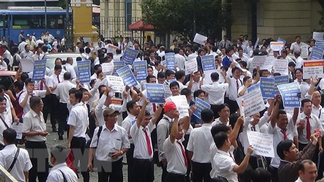 Hàng trăm tài xế taxi Vinasun cầm theo băngrôn, biểu ngữ đến dự phiên tòa hồi tháng 9/2018. (Ảnh: Thành Chung/TTXVN)