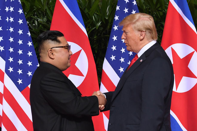 Cái bắt tay lịch sử giữa Tổng thống Mỹ Donald Trump và nhà lãnh đạo Triều Tiên Kim Jong-un tại Singapore ngày 12-6. 	Ảnh: AP