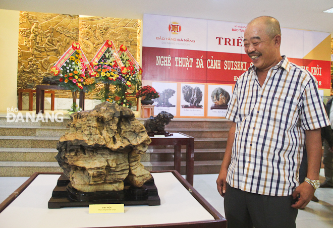 Collector Phan Khoi standing beside a Suiseki exhibit named ‘Imperial palace’.