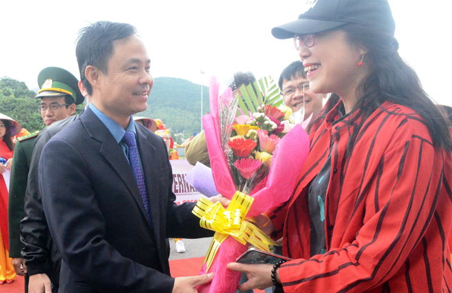 Ông Nguyễn Xuân Bình, Phó giám đốc Sở Du lịch thành phố (trái) tặng hoa cho vị khách trên chuyến tàu biển đầu tiên của năm mới.