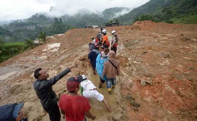 Rescue workers search for survivors at the site of a landslide triggered by heavy rain. (AFP)