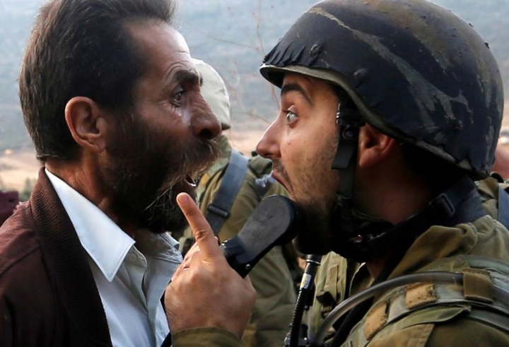 Một nam giới Palestine (trái) tranh cãi với lính Israel ở Bờ Tây vào tháng 10/2018.