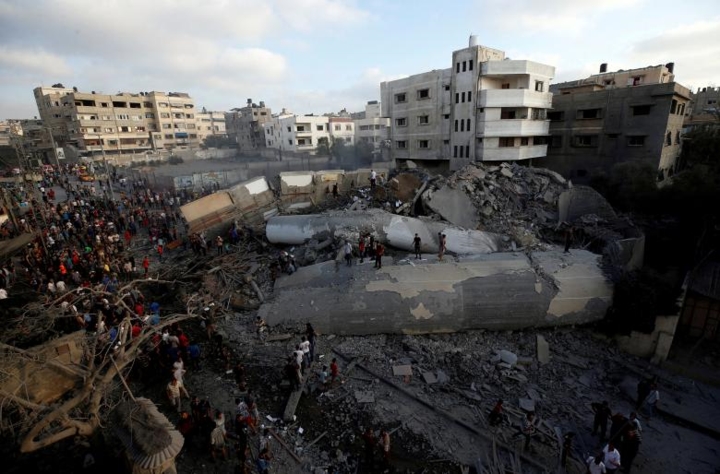   Người dân Palestine tụ tập quanh một tòa nhà trúng bom từ máy bay Israel, ở thành phố Gaza vào tháng 8/2018./.