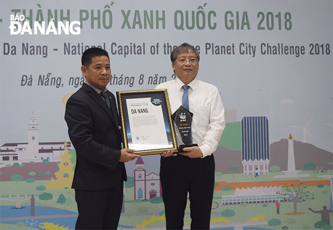 On behalf of the city leaders and citizens, Vice Chairman of the municipal People’s Committee Nguyen Ngoc Tuan (right) receiving a certificate of recognition of the city as the ‘National Capital of the World Wide Fund for Nature (WWF)’s One Planet City Challenge 2018 (OPCC)’ from Country Director of WWF-Viet Nam Van Ngoc Thinh.