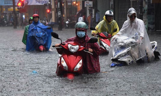 Road users managing to go through a flooded street