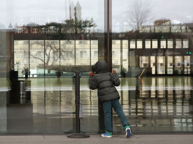 Một cậu bé 7 tuổi đứng ngoài nhìn vào trong bảo tàng. 