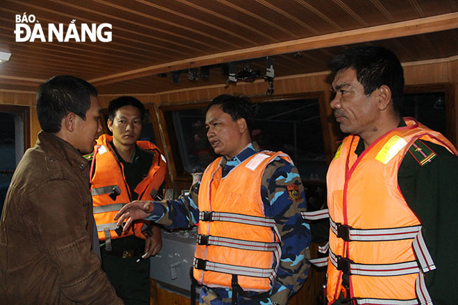 Representatives from the Da Nang Border Guard force meeting with a fisherman