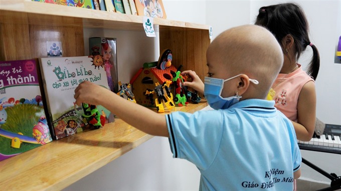 A cancer patient gets books at a hospital library in Da Nang. Nearly 1,000 books were donated to establish libraries at hospitals around the city.